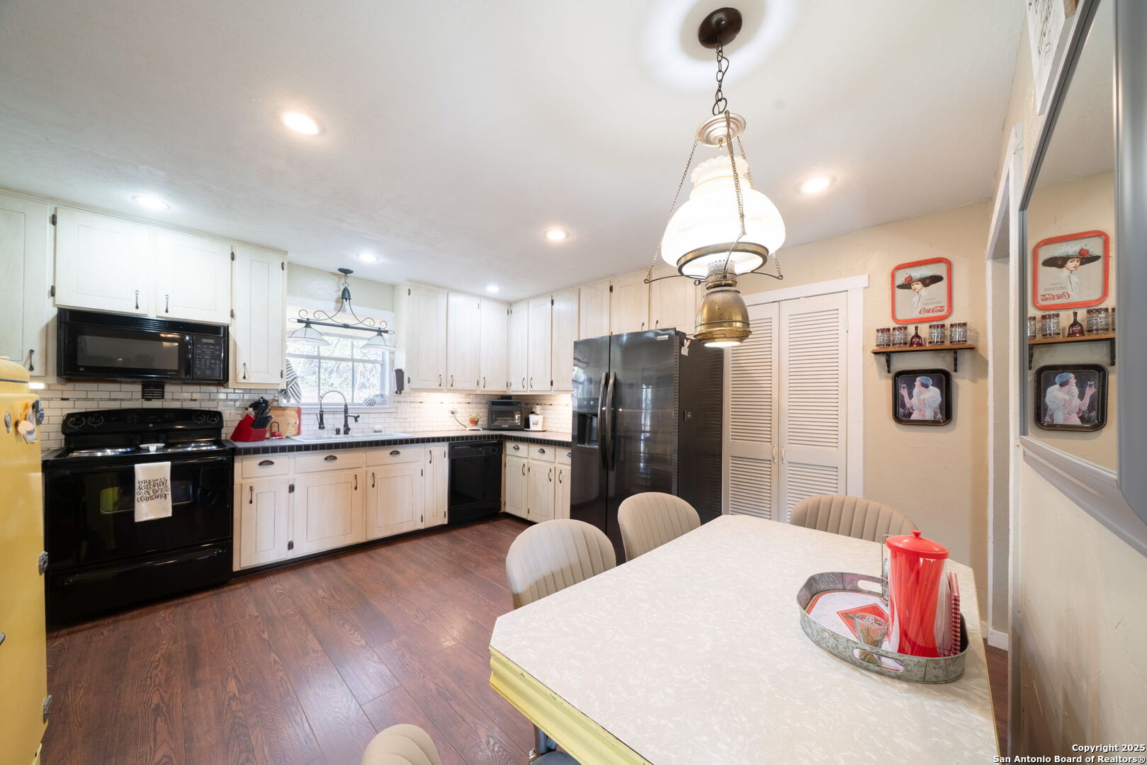 119 Post Oak Road La Vernia, TX 78121 - Photo 8 of 38 a kitchen with stainless steel appliances kitchen island granite countertop a refrigerator a sink dishwasher a stove and a dining table with wooden floor