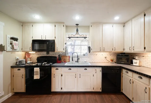 a kitchen with a sink stove top oven and cabinets