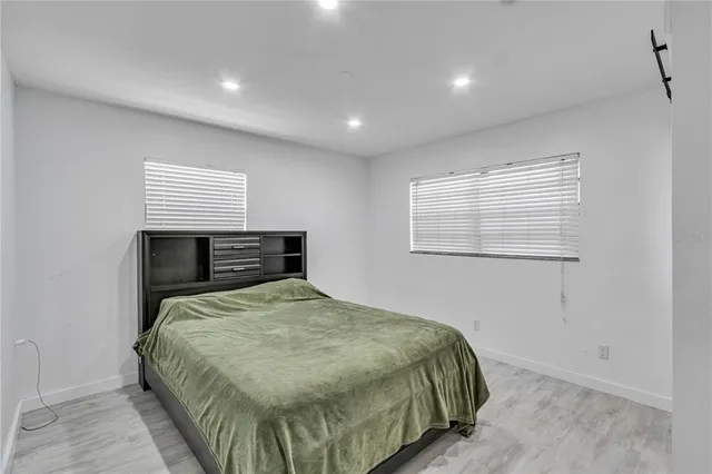 a bedroom with a bed and wooden floor