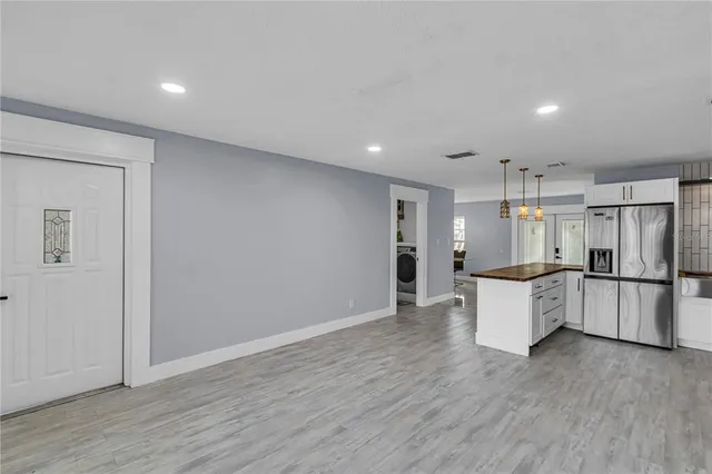 a large kitchen with a wooden floor and stainless steel appliances