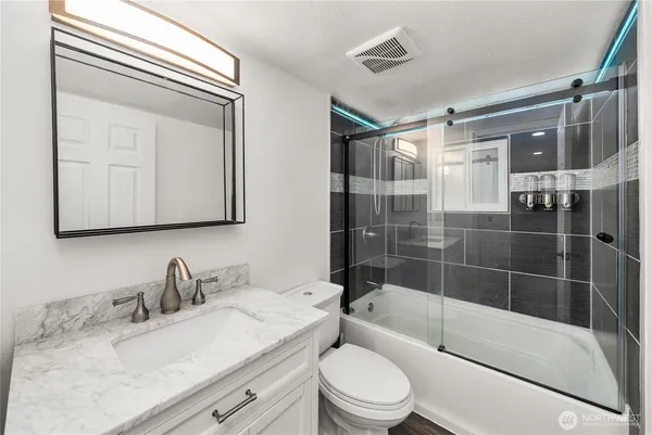 a bathroom with a granite countertop sink toilet and shower