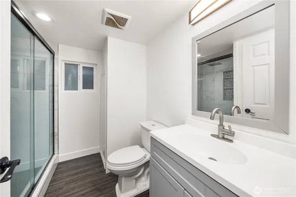 a bathroom with a sink a toilet and shower