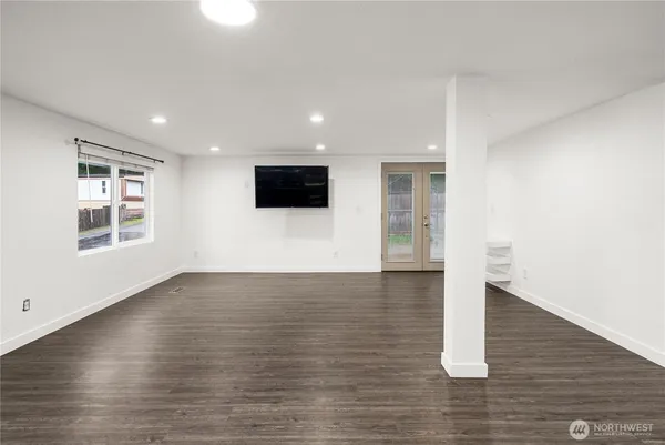 a view of empty room with wooden floor and window