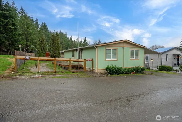 a front view of a house with a yard and trees