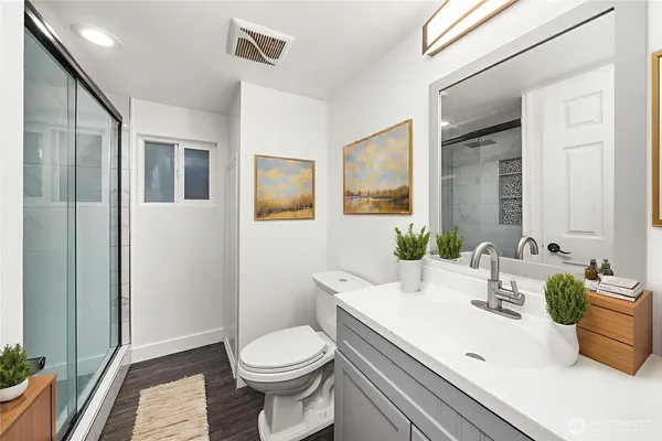 a bathroom with a sink a toilet and shower