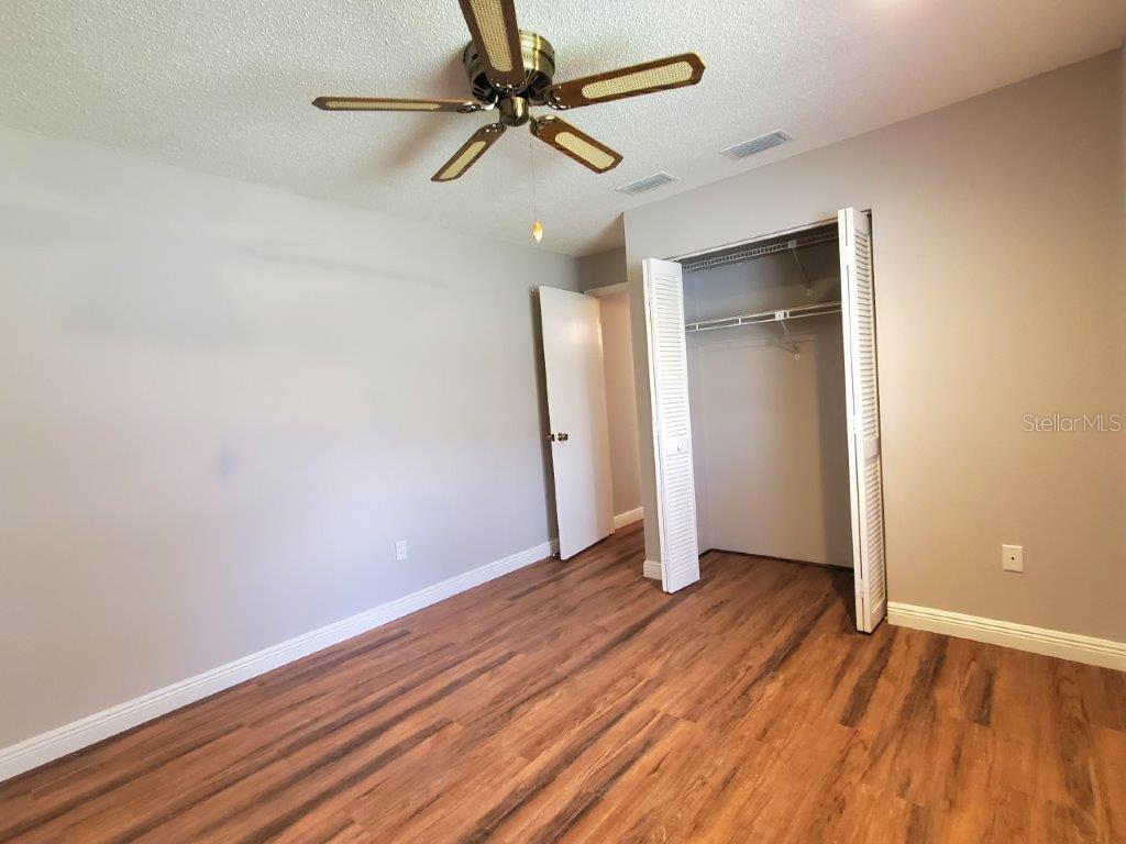 26014 Ocelot Lane Punta Gorda, FL 33983 - Photo 31 of 35 an empty room with wooden floor fan and windows