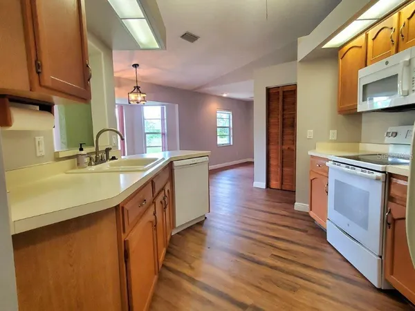 a kitchen with stainless steel appliances granite countertop a sink a stove and a wooden floors