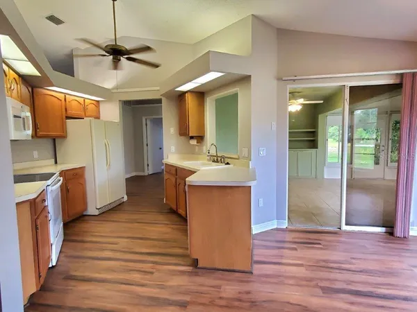 a large kitchen with stainless steel appliances granite countertop a sink and wooden floor