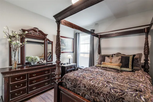 a bedroom with a bed and a dresser with mirror