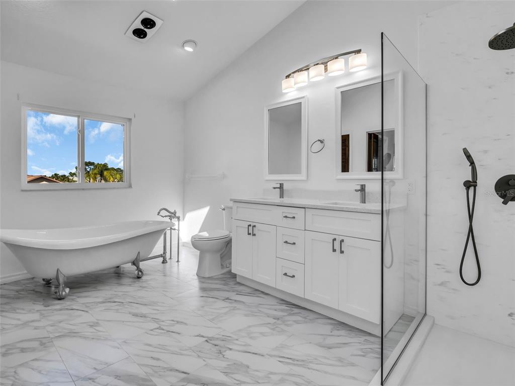 6241 Bayside Drive New Port Richey, FL 34652 - Photo 27 of 78 a bathroom with a double vanity sink toilet mirror and bathtub