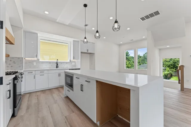 a kitchen with a sink stove and cabinets
