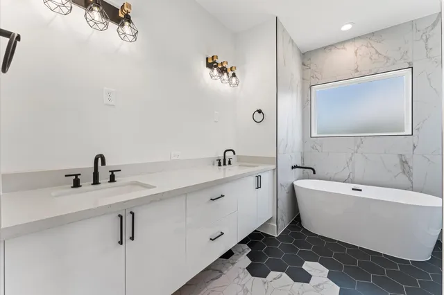 a bathroom with a bathtub shower sink vanity and toilet