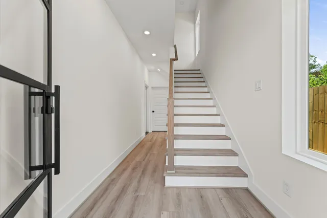 a large kitchen with stainless steel appliances kitchen island a large counter top and a wooden floors