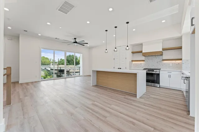 a large kitchen with kitchen island a stove a sink a center island and windows