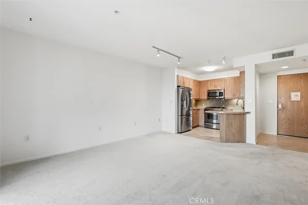 a view of kitchen with stainless steel appliances a refrigerator and a stove top oven