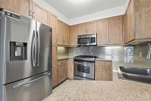 a kitchen with stainless steel appliances granite countertop a refrigerator stove a sink and dishwasher