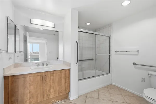 a bathroom with a granite countertop sink mirror and toilet