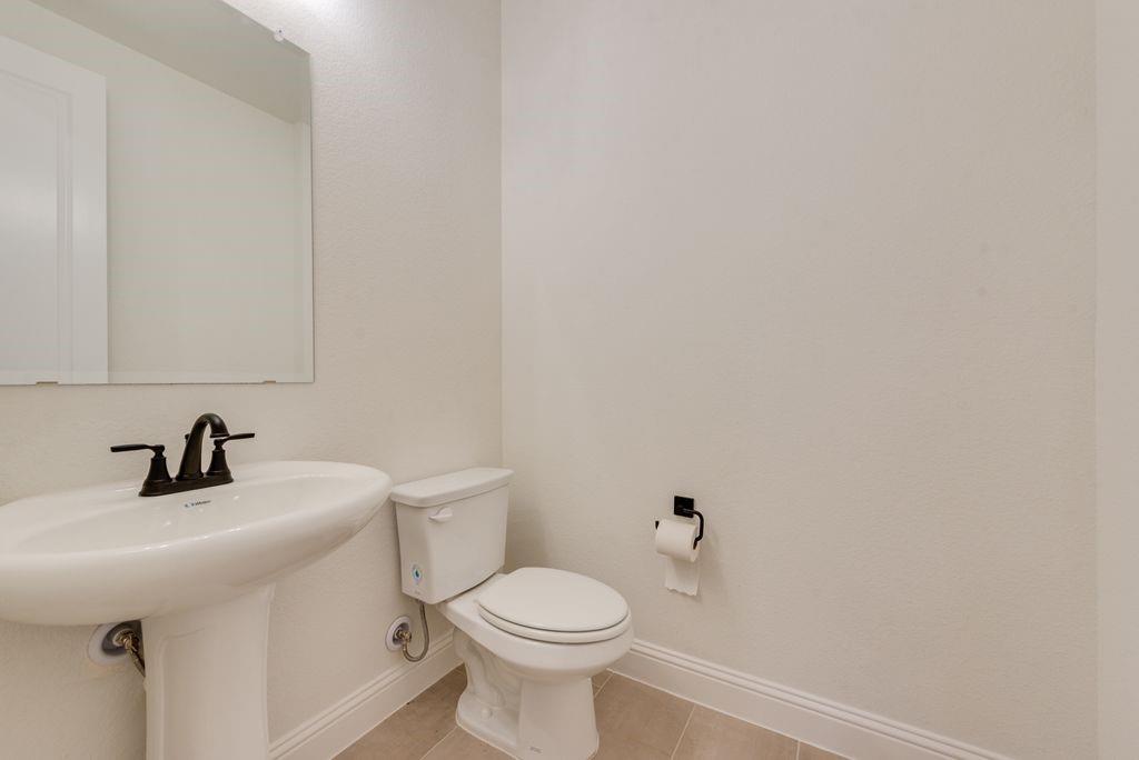 809 Turnbull Avenue Justin, TX 76247 - Photo 12 of 22 a bathroom with a sink a toilet and mirror