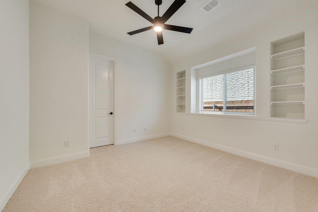 809 Turnbull Avenue Justin, TX 76247 - Photo 9 of 22 an empty room with a window and a ceiling fan