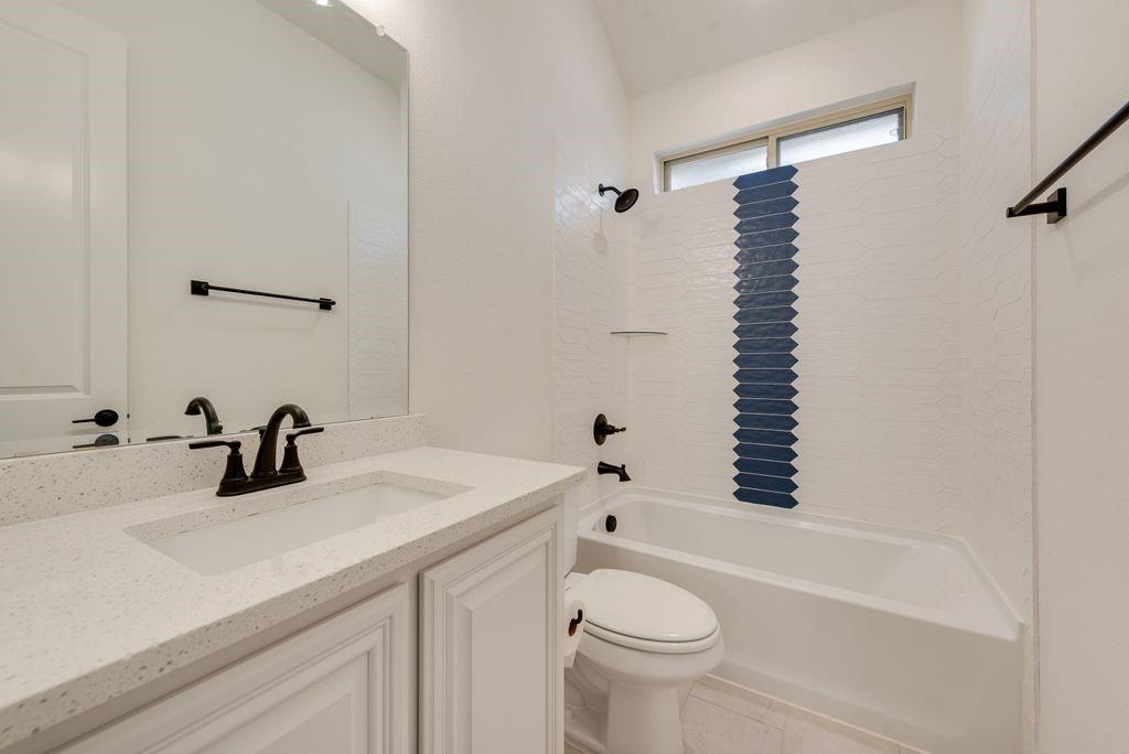809 Turnbull Avenue Justin, TX 76247 - Photo 10 of 22 a bathroom with a sink a toilet and shower