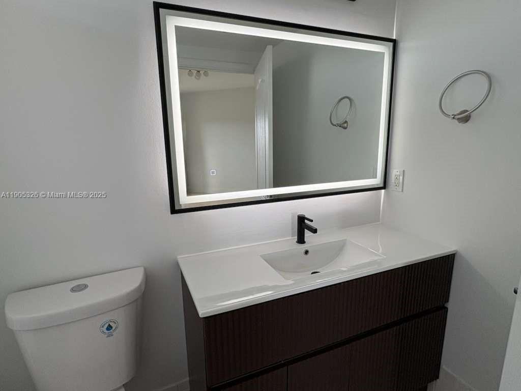 1627 Southwest 37th Avenue, Unit 207 Miami, FL 33145 - Photo 17 of 24 a bathroom with a sink and mirror with toilet