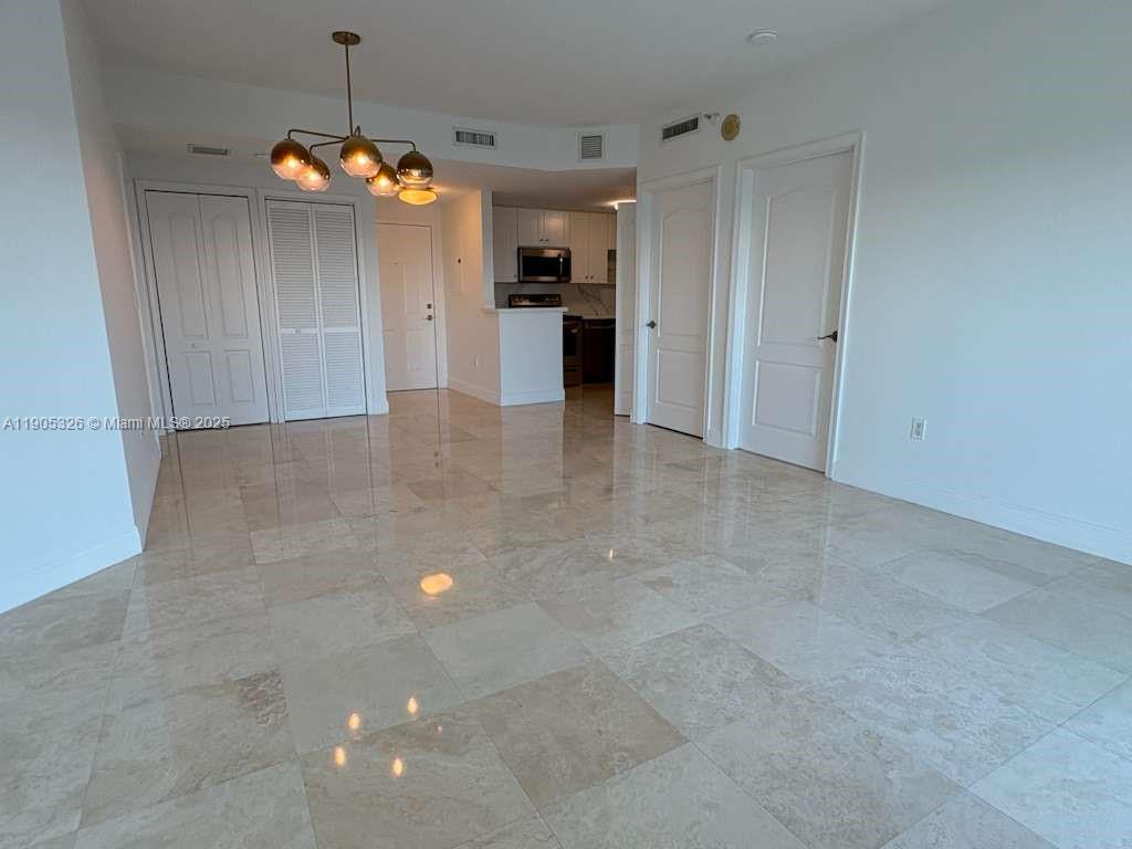 1627 Southwest 37th Avenue, Unit 207 Miami, FL 33145 - Photo 3 of 24 an empty room with an empty space and chandelier fan