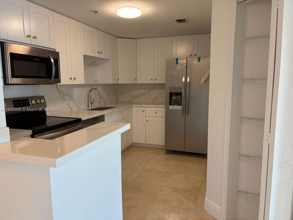 1627 Southwest 37th Avenue, Unit 207 Miami, FL 33145 - Photo 4 of 24 a kitchen with a refrigerator stove and microwave