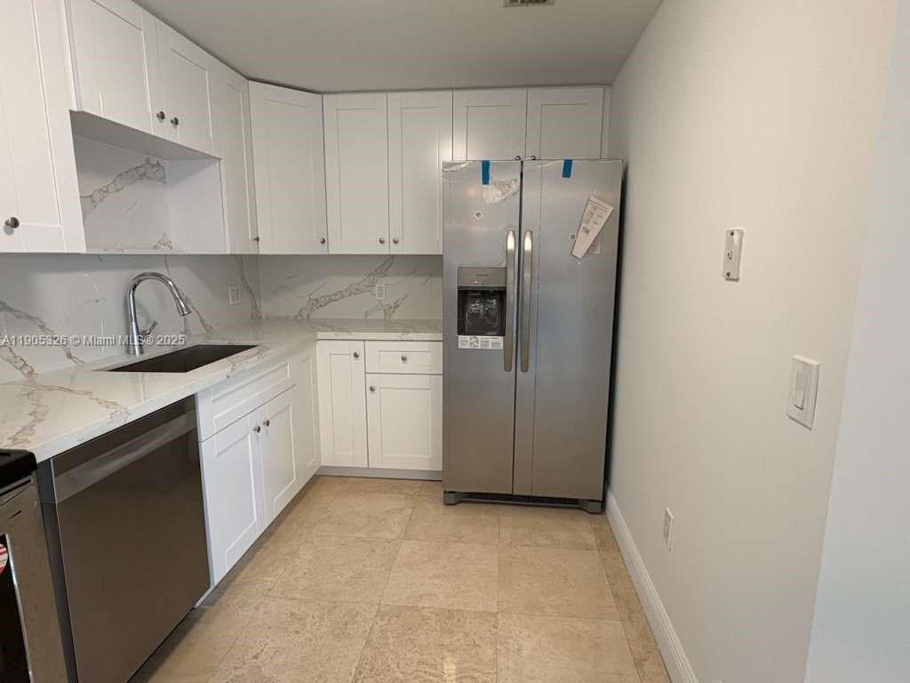 1627 Southwest 37th Avenue, Unit 207 Miami, FL 33145 - Photo 5 of 24 a kitchen with a sink a refrigerator and cabinets