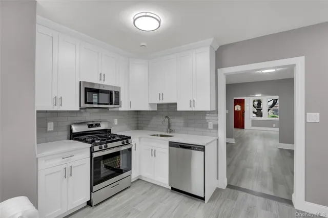a kitchen with white cabinets and white appliances