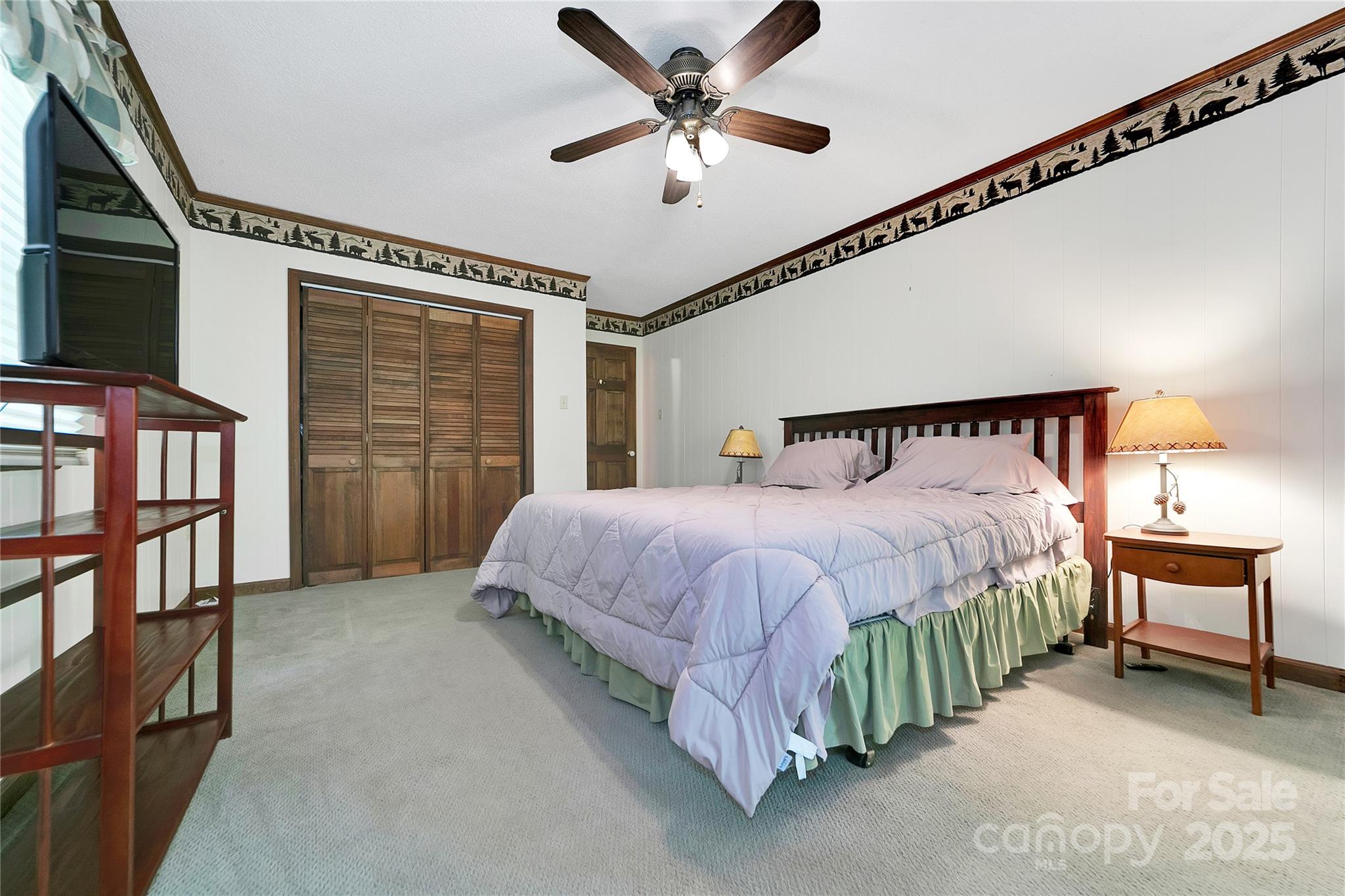 261 Franks Cove Road Brevard, NC 28712 - Photo 16 of 34 a bedroom with a bed next to a ceiling fan