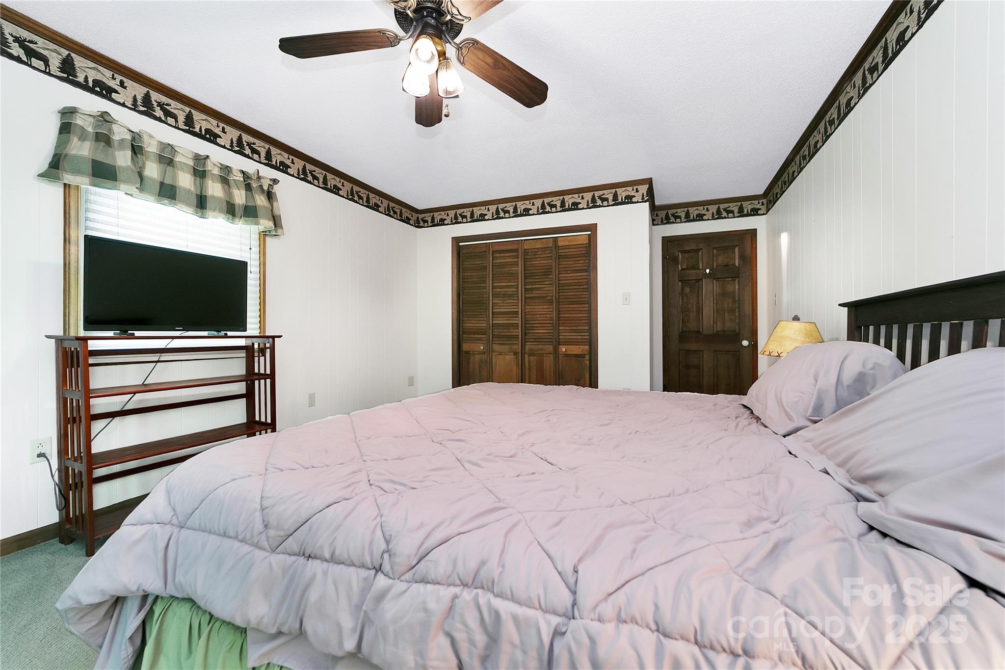 261 Franks Cove Road Brevard, NC 28712 - Photo 17 of 34 a bedroom with a bed and a chandelier