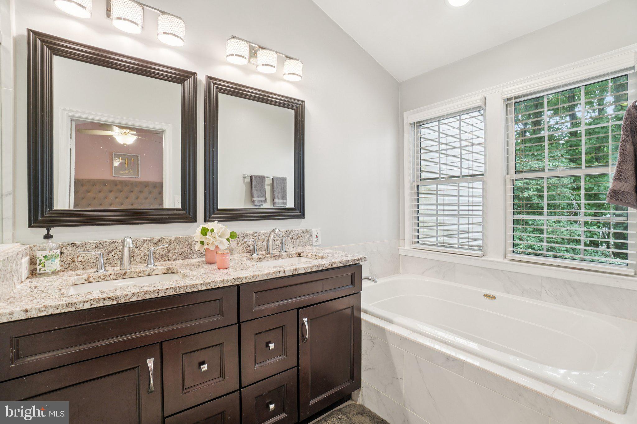 11742 Valley Ridge Circle Fairfax, VA 22033 - Photo 17 of 34 a bathroom with a tub double sink window and mirror