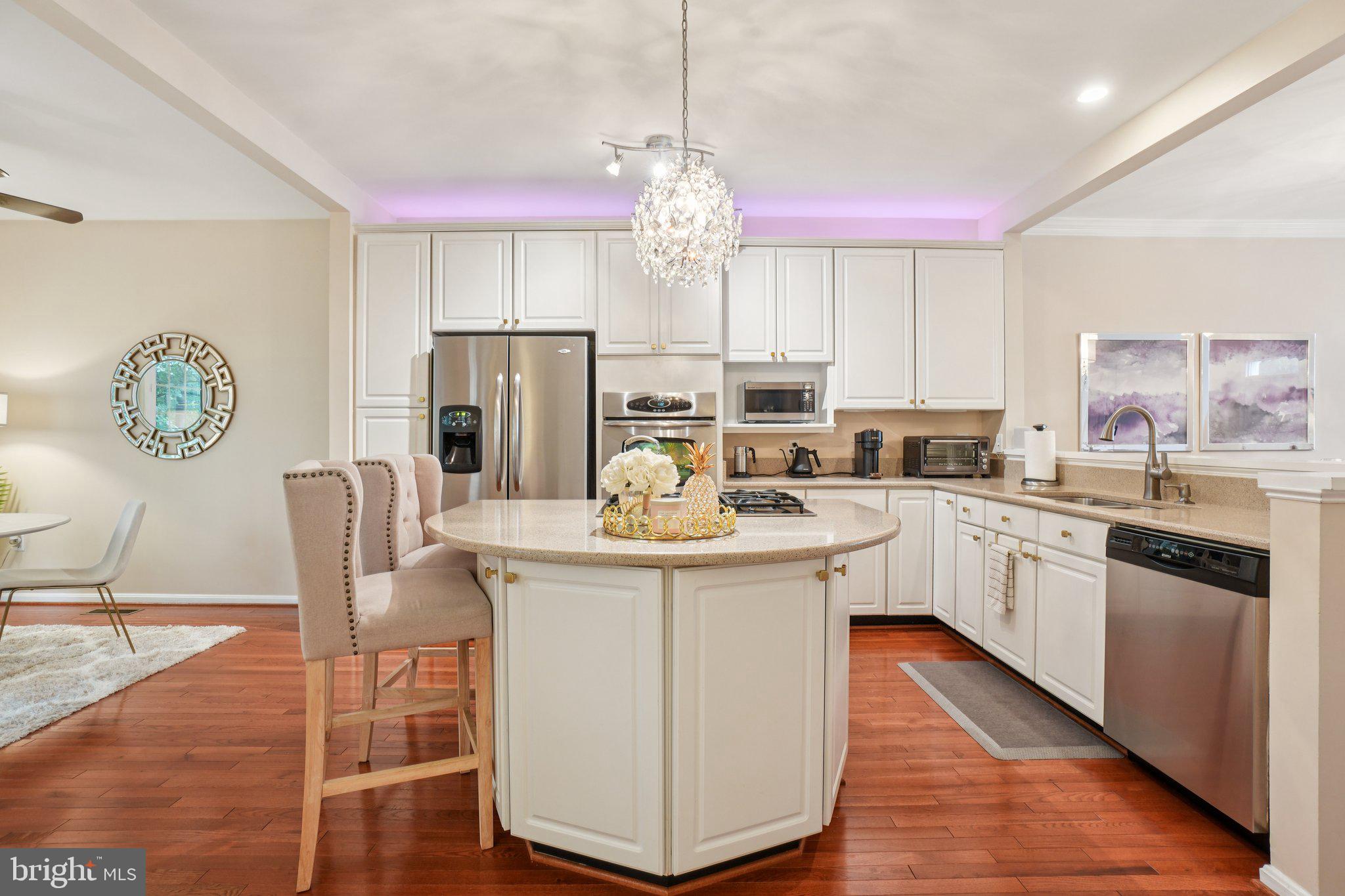 11742 Valley Ridge Circle Fairfax, VA 22033 - Photo 10 of 34 a kitchen with kitchen island granite countertop a stove a sink a refrigerator cabinets and dining table