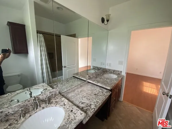 a bathroom with a granite countertop sink and a mirror