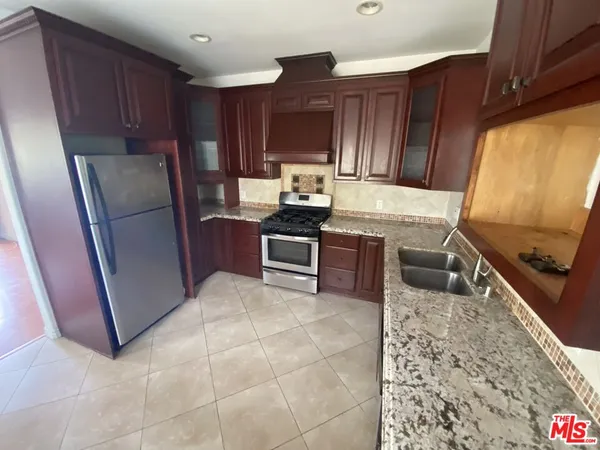 a kitchen with stainless steel appliances granite countertop a refrigerator stove and sink