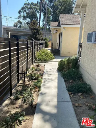 a view of a pathway of a house with a yard