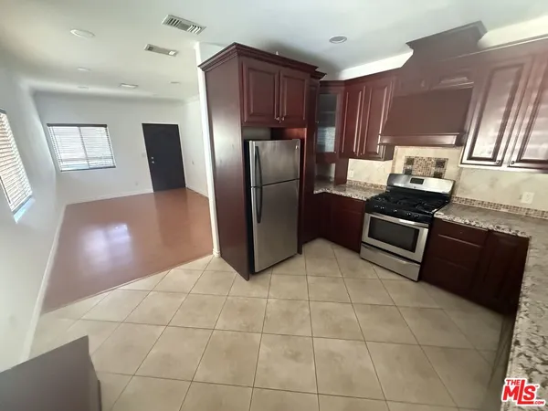 a kitchen with granite countertop a refrigerator and a sink