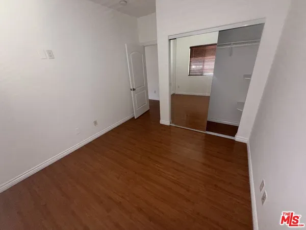 an empty room with wooden floor and closet