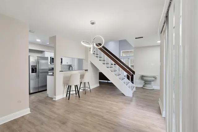 a living room with stainless steel appliances furniture and a view of kitchen