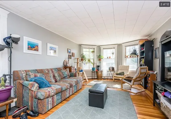 a living room with furniture a flat screen tv and a window
