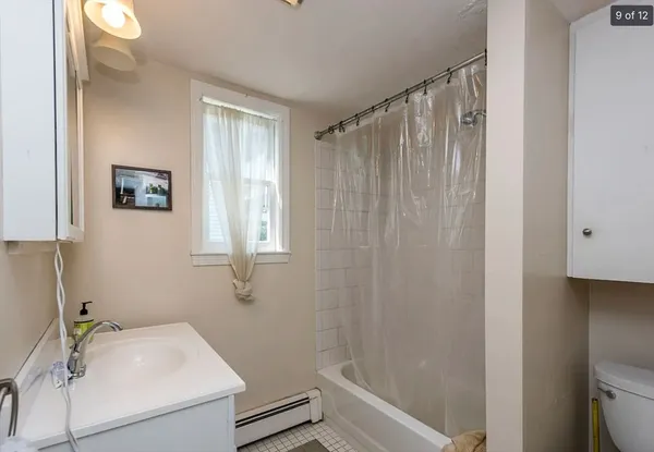 a view of a house with a small yard and wooden fence