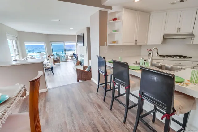 a living room with stainless steel appliances granite countertop furniture and wooden floor