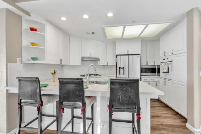 a kitchen with refrigerator cabinets dining table and chairs
