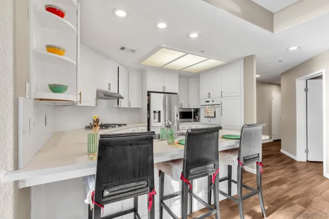 a kitchen with stainless steel appliances granite countertop a refrigerator and a stove top oven