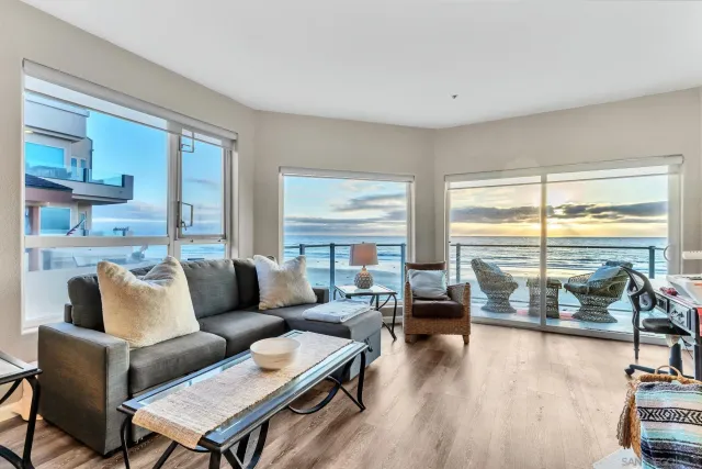 a living room with furniture and floor to ceiling window next to a large window