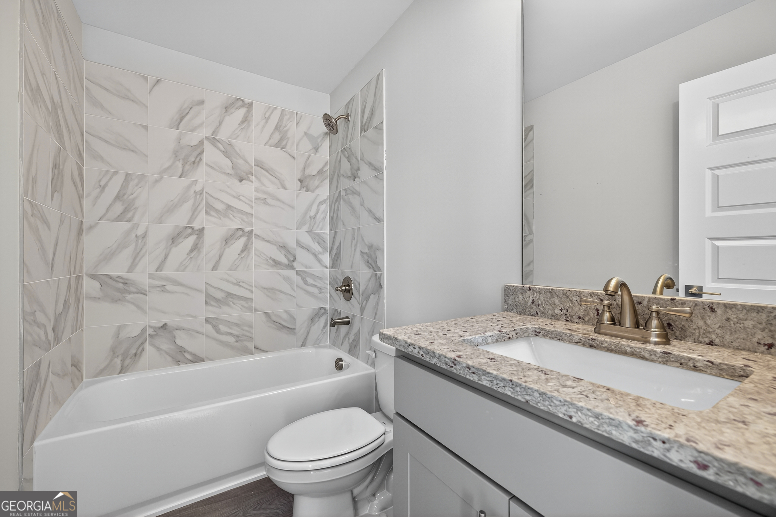 112 Patillo Manor, Unit 3 Stockbridge, GA 30281 - Photo 57 of 59 a bathroom with a granite countertop sink toilet and bathtub