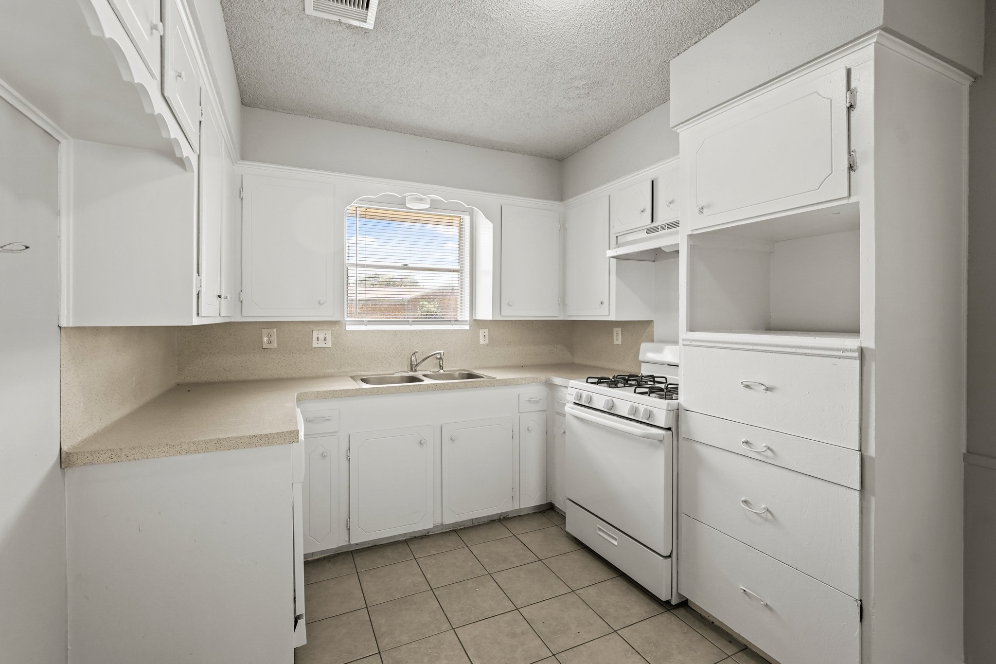 1802 Mosher Lane Houston, TX 77088 - Photo 12 of 18 a kitchen with white cabinets and white appliances
