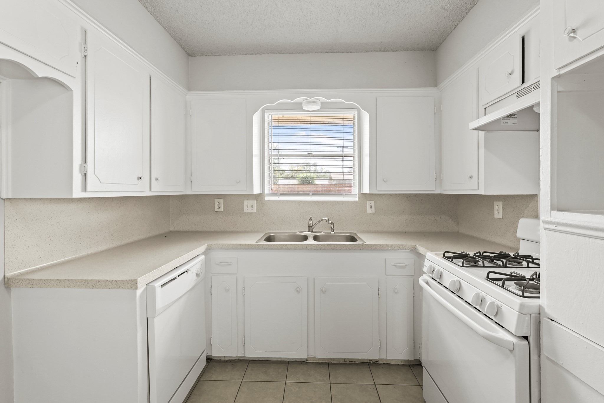 1802 Mosher Lane Houston, TX 77088 - Photo 13 of 18 a kitchen with cabinets appliances a sink and a window