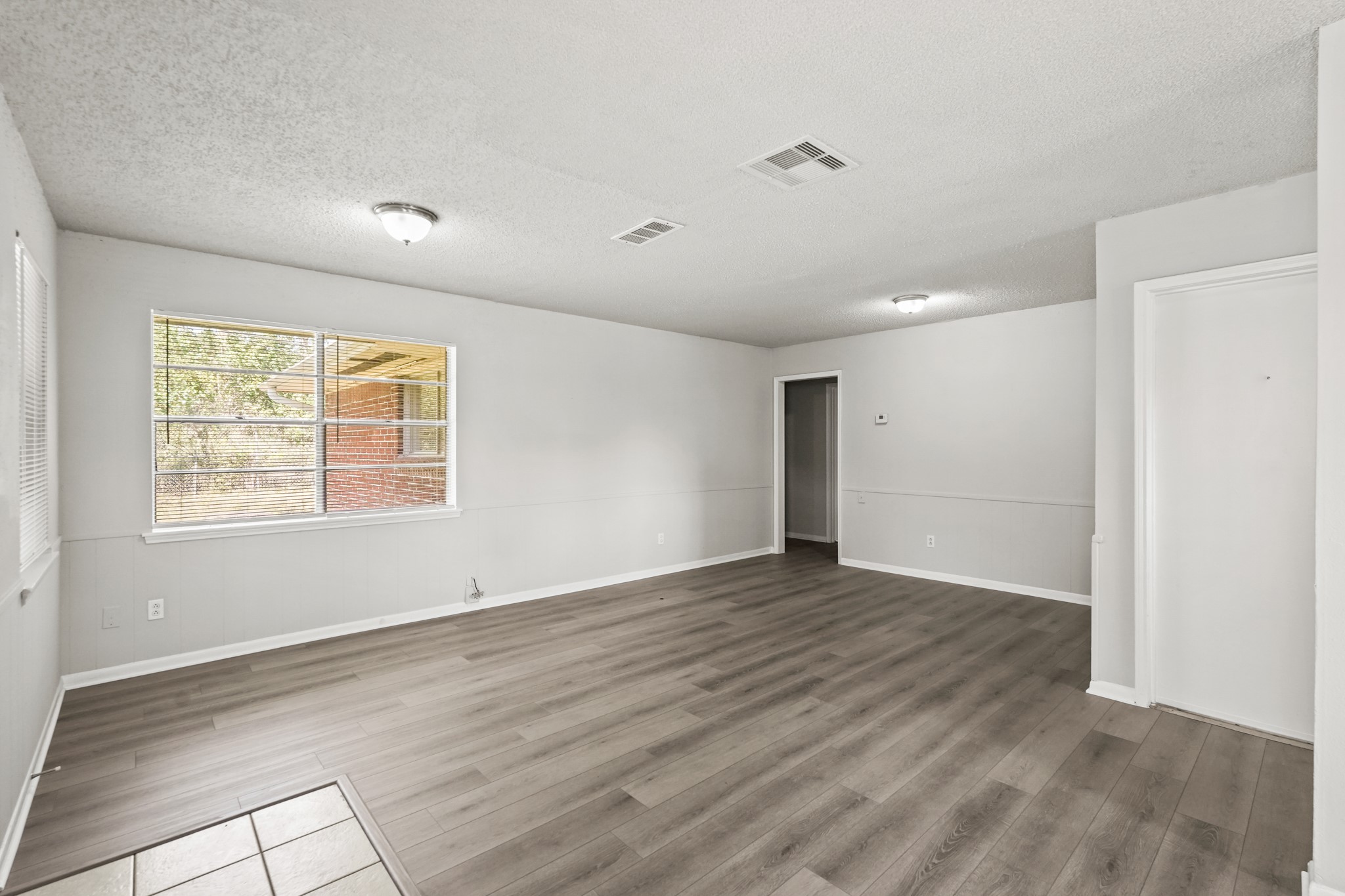1802 Mosher Lane Houston, TX 77088 - Photo 4 of 18 an empty room with wooden floor and windows