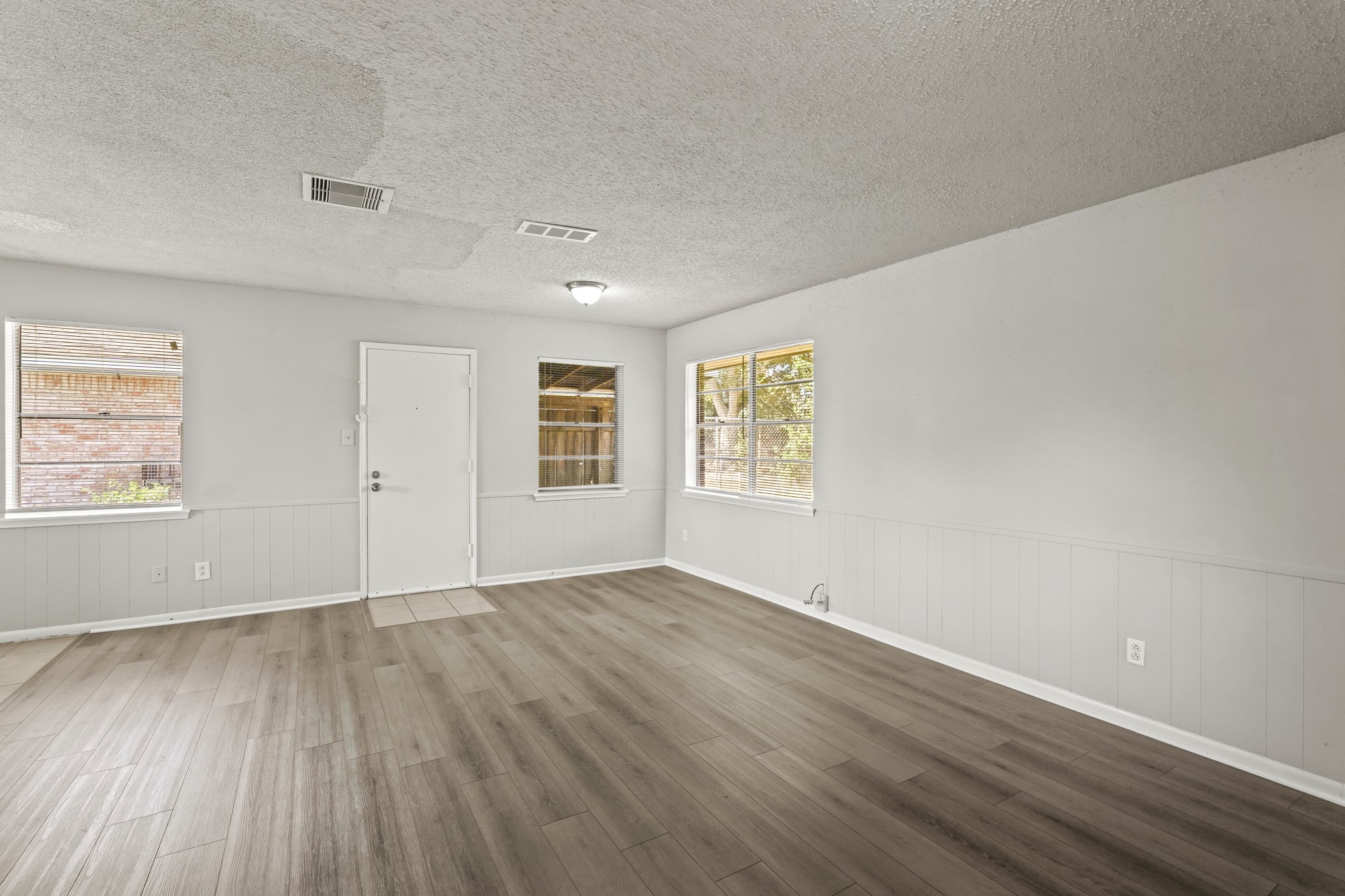 1802 Mosher Lane Houston, TX 77088 - Photo 9 of 18 an empty room with wooden floor and windows